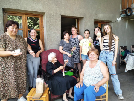 Photo : Une vieille personne démontre comment filer la laine